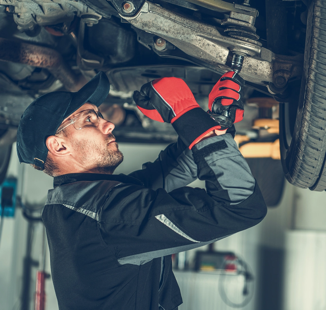 Mechanic working under a car lift.