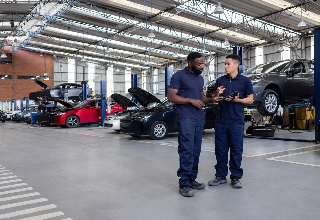 Mechanics discussing in an auto repair shop.