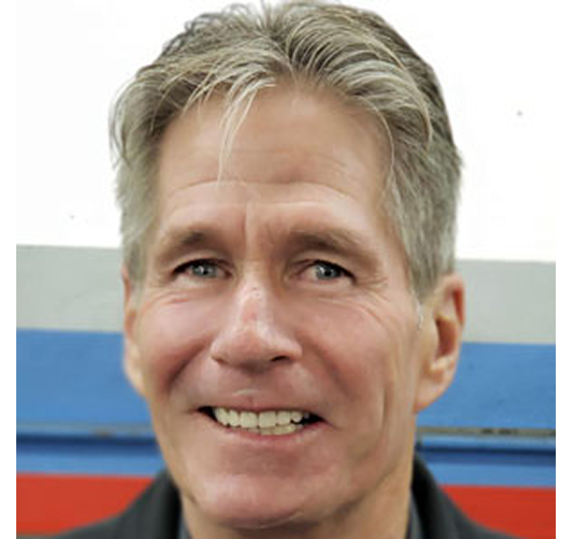 Smiling man with short gray hair.